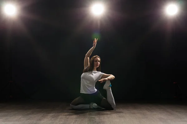 Dance, hip-hop, jazz funk and people concept - flexible young woman dancing in the darkness under the light — Stock Photo, Image