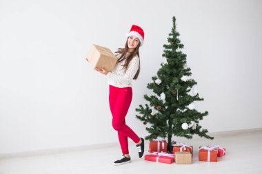 Noel, tatil ve hediyeler kavramı - santa şapka hediye kutusu beyaz arka planda tutan kadın