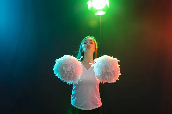 Animadora joven bailando con pompones sobre fondo colorido — Foto de Stock