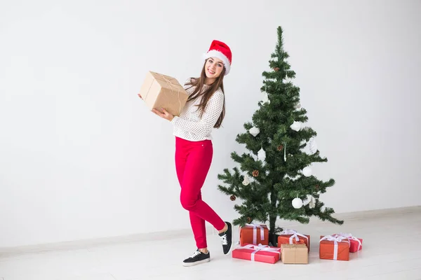 Natal, feriados e apresenta conceito - mulher em santa chapéu segurando caixa de presente no fundo branco — Fotografia de Stock