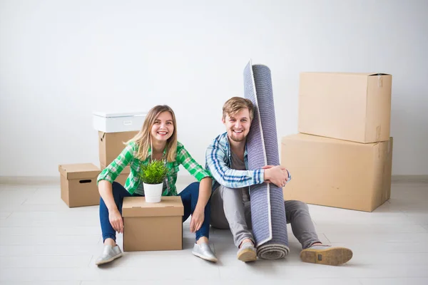 Relocation, real estate and moving concept - young couple people moved to a new apartment — Stock Photo, Image