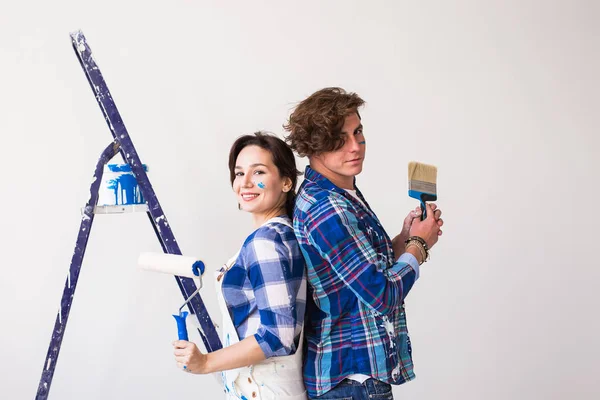 Командная работа, любовь пара, ремонт и ремонт концепции - молодая роспись стены, смех и выглядеть очень счастливым — стоковое фото