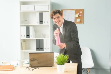 Office, mizah, espri ve iş insanlar kavramı - saksılı bitki sulama ofiste çalışan yakışıklı adam