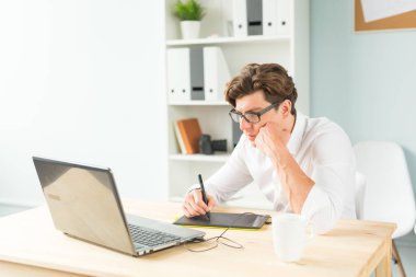 İş, tasarım ve insanlar kavramı - beyaz gömlekli grafik tablet ahşap masa kullanma yakışıklı genç