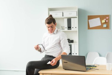 İnsanlar, eğlence ve iş kavramı - genç işadamı onun gözlük temizler.