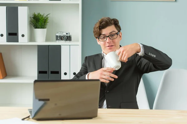 Gente de negocios, broma y tontos concepto de día - joven empresario divertido derramando té en la oficina — Foto de Stock