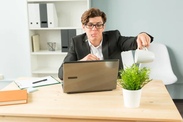 Business people, humor and people concept - Handsome office man is watering the potted plant