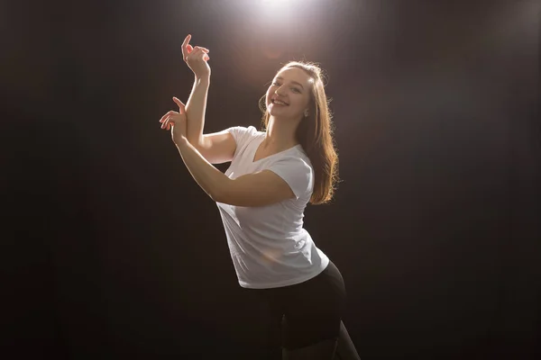 Pessoas e conceito de dança - Jovem bela mulher esportiva dançando jazz funk em um fundo de estúdio preto — Fotografia de Stock