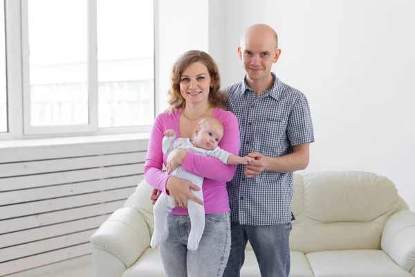 Childgood, parenthood, people concept - baby on the hands of parents on a white background.