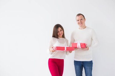 Yılbaşı, bayram, Sevgililer günü ve Doğum günü kavramı - beyaz zemin üzerine hediyelerle mutlu erkek ve kadın tutar kutuları alanı Kopyala