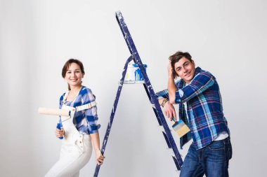 Yenileme, onarım ve insanlar kavramı - çift belgili tanımlık duvar ve bakmak çok mutlu boyama için gidiyor.