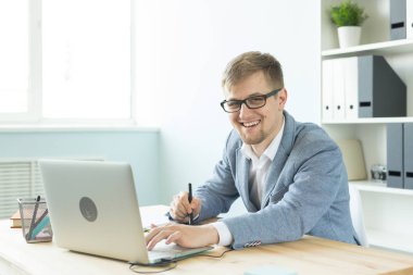 Tasarımcı, sanatçı ve web tasarım konsepti - ofiste dijital kalem tablet ve dizüstü bilgisayar kullanan genç adam portresi