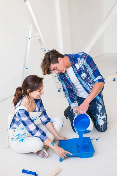 Réparation, couleur, rénovation et concept de personnes - couple va peindre le mur, ils mélangent la couleur — Photo