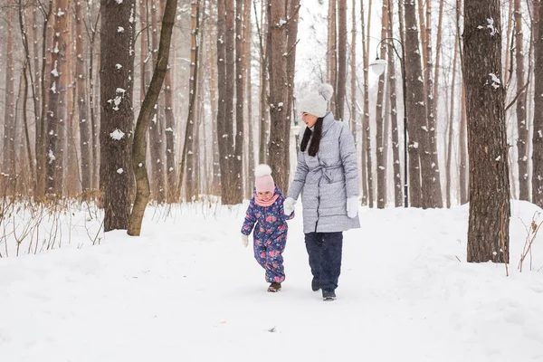 Gelukkige familie concept - moeder en kind meisje op een winter wandeling in de natuur. — Stockfoto