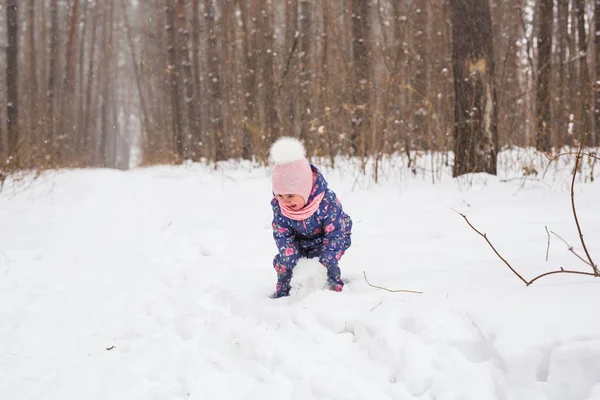 雪に覆われた森での実行の子。野外で遊ぶ幼児子供。雪の降る公園での子供遊び. — ストック写真