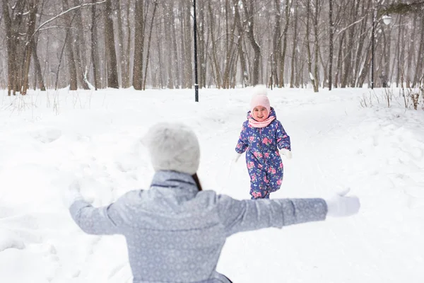 Conceito de família e natureza - Mãe com filha se divertir no parque de inverno — Fotografia de Stock