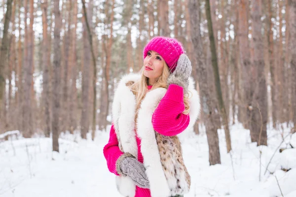 Natur, mode och vinter koncept - ganska ung kvinna i rosa varm jacka i snöig park — Stockfoto