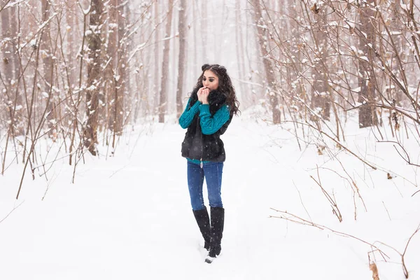 Jeune jolie femme marchant dans le parc enneigé d'hiver à la journée ensoleillée — Photo