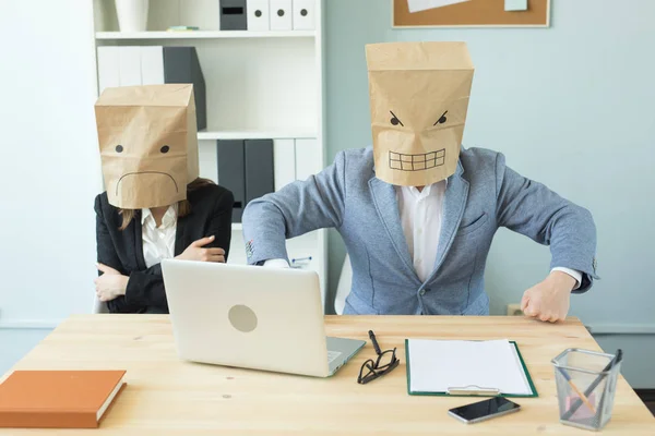 Business, emotions and people concept - woman and man wearing the packages on their heads with pictured emotions anger and fear