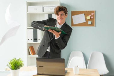 İş, mizah ve insanlar kavramı - yakışıklı ve genç bir adam elbiseli yaprak kağıt atar..