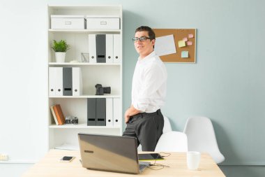 İş, ofis, insanlar kavramı - gözlük standları bir bilgisayarın yakınında ofiste yakışıklı adam ve gülümseyen