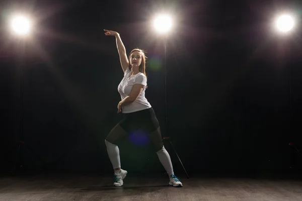 Joven hermosa mujer delgada bailando jazz-funk en un fondo de estudio negro — Foto de Stock