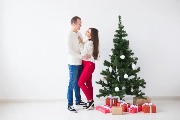 Együtt ünnepli a karácsonyt. Gyönyörű fiatal pár áll közel karácsonyfa — Stock Fotó