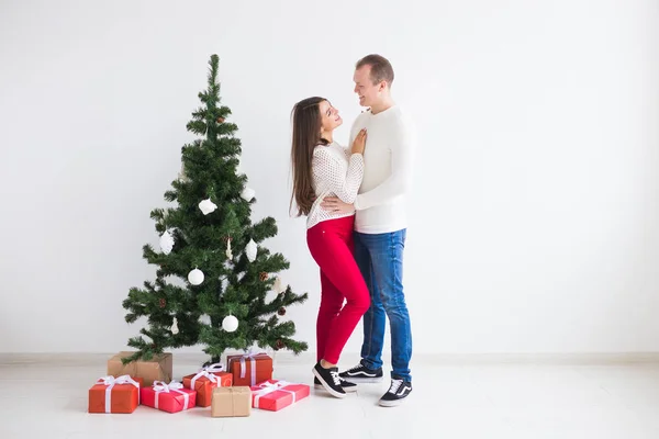 Osób, Boże Narodzenie, święta i nowy rok koncepcja - szczęśliwy miłość para w swetry, stojący w pobliżu choinki — Zdjęcie stockowe