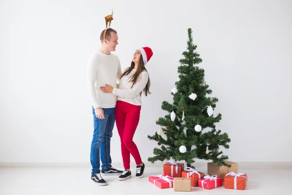 Téli ünnepek koncepció - karácsonyi pár viselt Santa kalap és a szarvas szarv. Mosolygó családi ünnep — Stock Fotó
