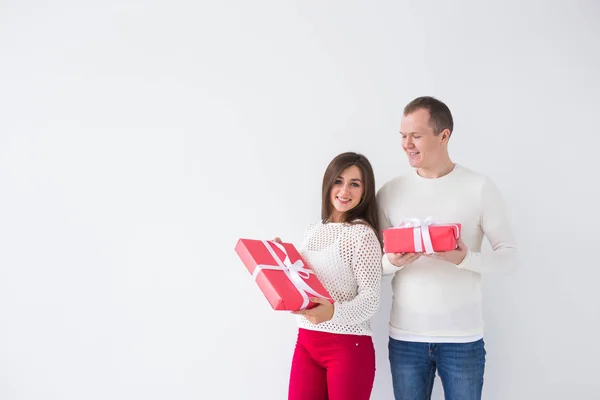 Navidad, vacaciones, día de San Valentín y concepto de cumpleaños - Feliz hombre y mujer sostiene cajas con regalos sobre fondo blanco con espacio para copiar — Foto de Stock