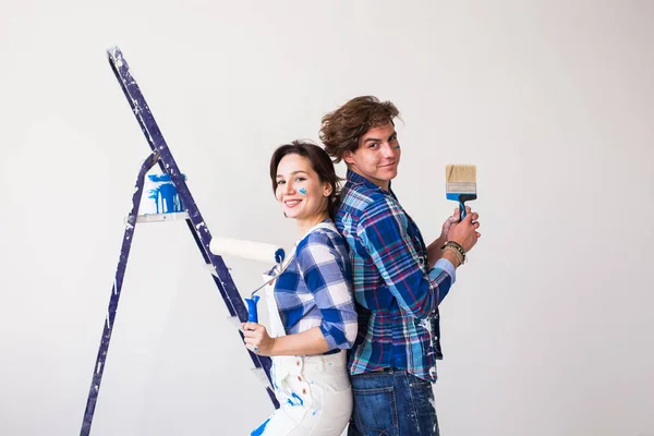 Concept de travail d'équipe, réparation et rénovation - Homme et femme recouverts de peinture dans un nouvel appartement — Photo