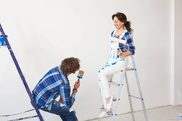 Ekip çalışması, tadilat ve onarım kavramı - erkek ve kadın merdivenler üzerinde oturan boya kaplı — Stok fotoğraf