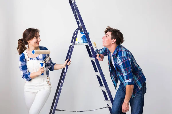 Trabalho em equipe, renovação e conceito de reparo - Retrato de casal engraçado fazendo redecoração em apartamento — Fotografia de Stock