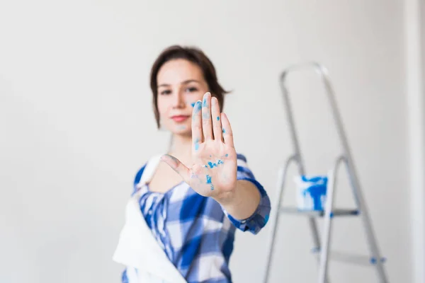 Personas, renovación y concepto de apartamento - Primer plano retrato de mujer joven atractiva con la cara pintada y la mano — Foto de Stock