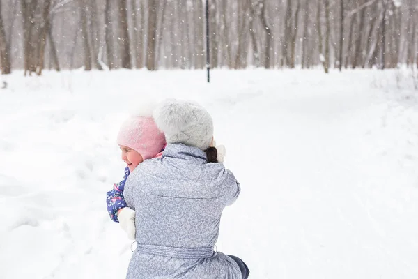 Concept famille, enfants et nature - Mère et fille s'amusent dans le parc d'hiver — Photo