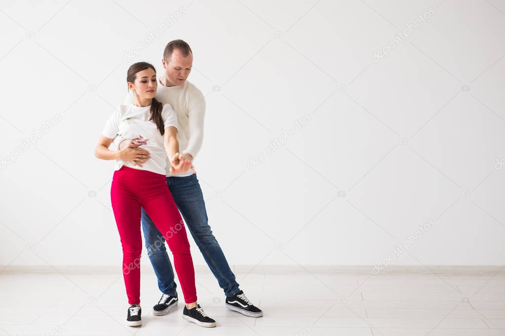 Happy couple dancing social dance kizomba vs bachata or salsa or zouk on light background