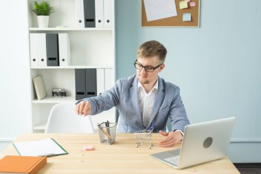 Ofis, iş adamları, sonu kavramı - Yöneticisi çalışmaları sırasında Oyuncak süpermarket arabası ile ofiste ile oynuyor.