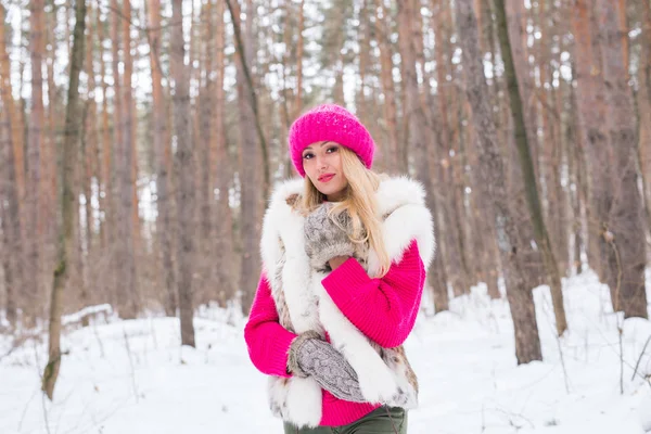 Beleza, moda, conceito de pessoas - mulher loira atraente andando em chapéu rosa e suéteres em madeira de inverno — Fotografia de Stock