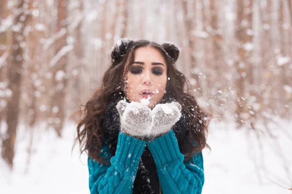 クリスマスの女の子。冬の自然の雪を吹く冬の若い女性 — ストック写真