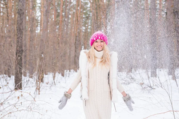 Divertimento, inverno e concetto di persone - Donna attraente vestita con cappotto bianco gettando neve . — Foto Stock