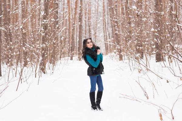 Télen, a szezonban és az emberek koncepció - fiatal csinos nő séta a havas park — Stock Fotó
