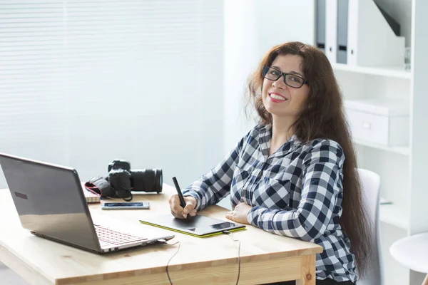 Illustrator, web designer and artist concept - Graphic designer using her pen tablet in a bright office