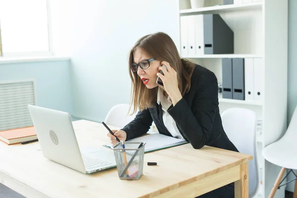 Büro-, Geschäfts- und Personenkonzept - glückliche Geschäftsfrau, die mit dem Handy telefoniert und sich auf dem Schreibtisch im Büro Notizen macht — Stockfoto