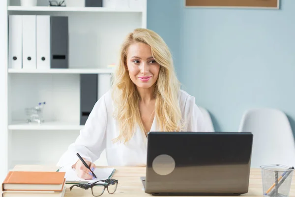 Concept technologie, travail et personnes - Belle femme blonde assise à son bureau et travaillant sur un ordinateur portable — Photo