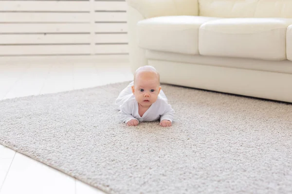 Barndom, spädbarn och personer koncept - baby flicka lära sig att krypa på golvet — Stockfoto