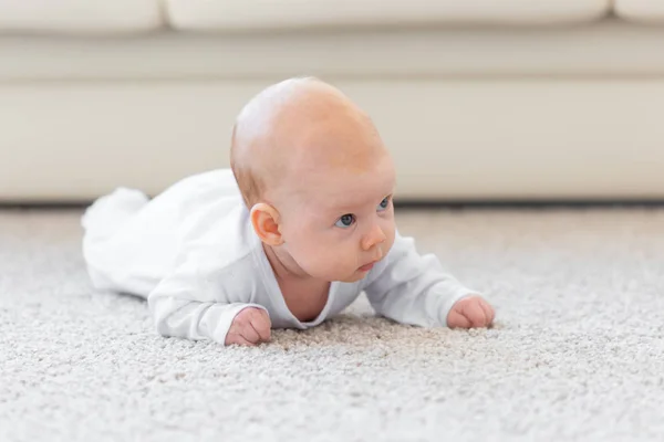 童年、婴儿和人的概念--女婴学习爬在地板上 — 图库照片