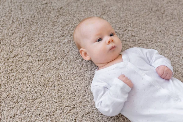 童年、婴儿和人的概念--躺在地板上的小婴儿 — 图库照片