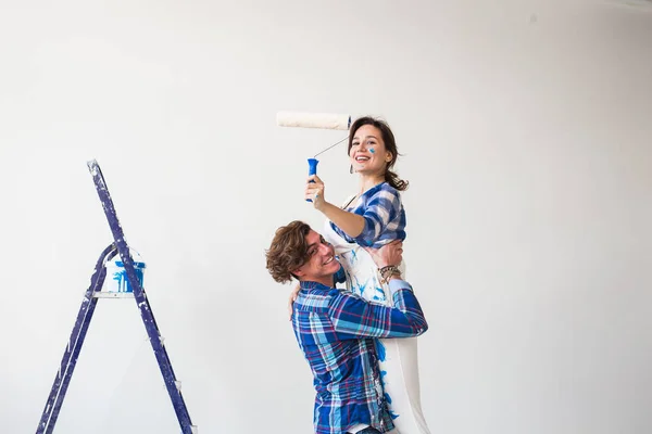 Renovatie, reparatie en familie concept - een jong koppel doet een reparatie in nieuwe woning — Stockfoto