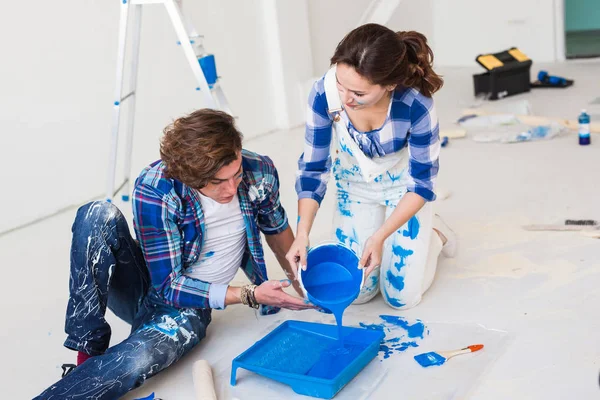 Reparación, renovación y concepto de personas - Primer plano retrato de pareja verter pintura — Foto de Stock