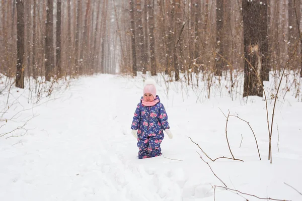 Семья, дети и природа - маленькая девочка развлекается в зимнем парке — стоковое фото